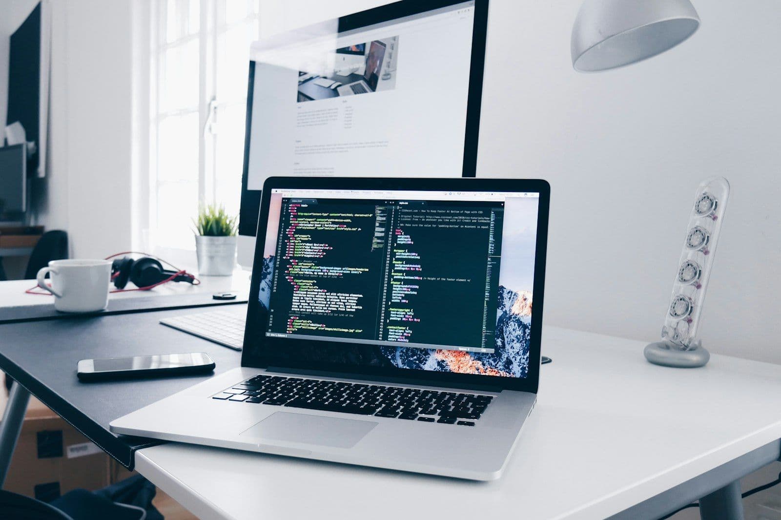 Laptop showing source code on a developer's desk